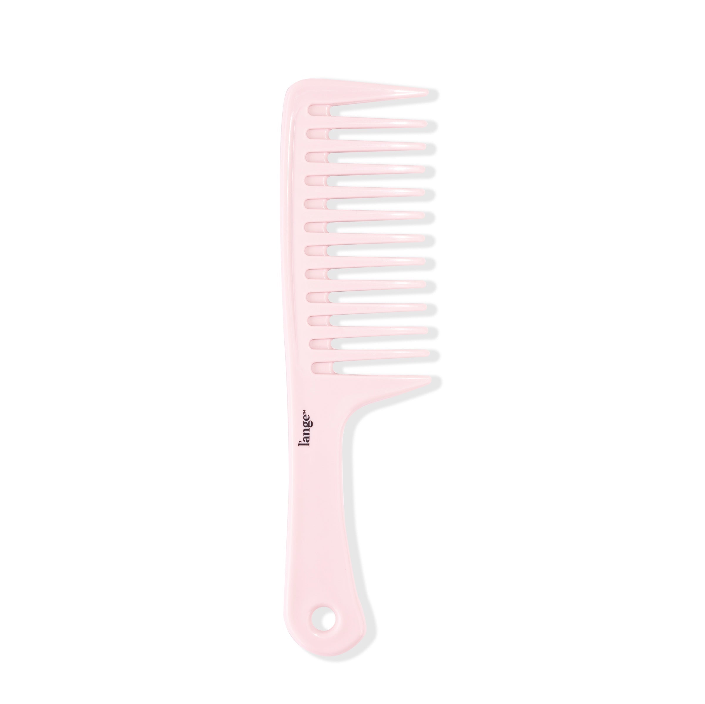 The pink detangling comb stands vertically, showing its widely-spaced teeth and flat handle.