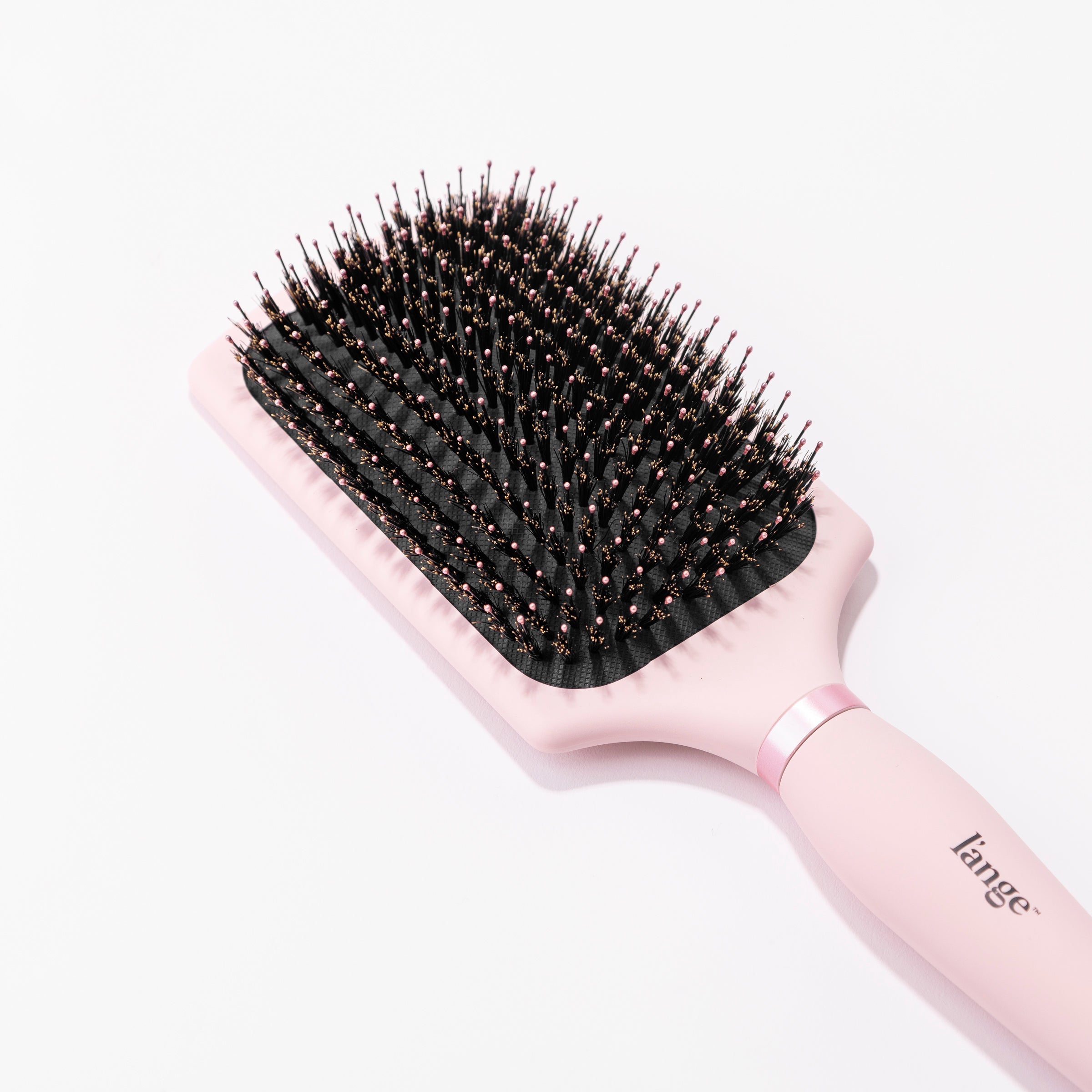 The close-up of this pink Siena Paddle Brush shows the boar bristles surrounding the nylon bristles.
