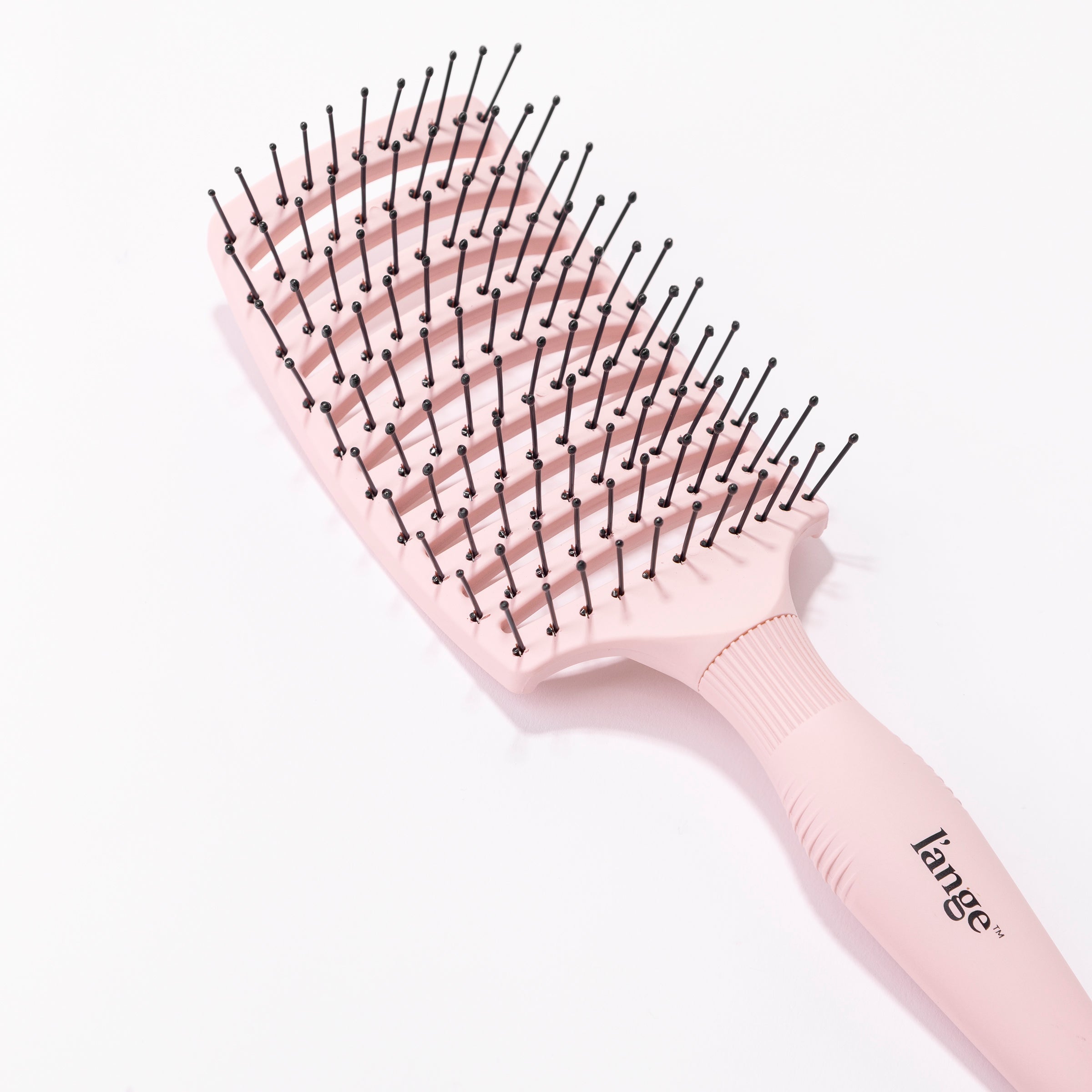This close-up shows the pink vent brush curved, flexible design and black nylon-tipped bristles.