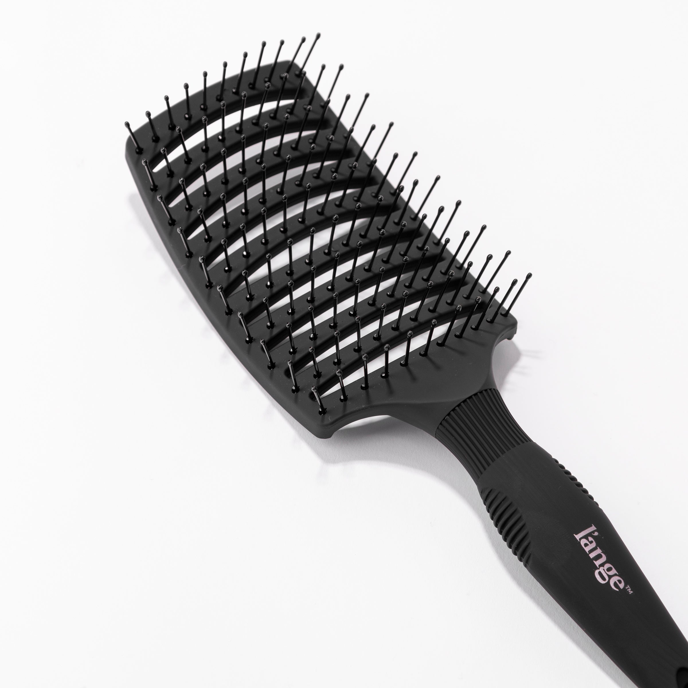 This close-up displays the black, wide, vent brush curved, flexible design & nylon-tipped bristles.
