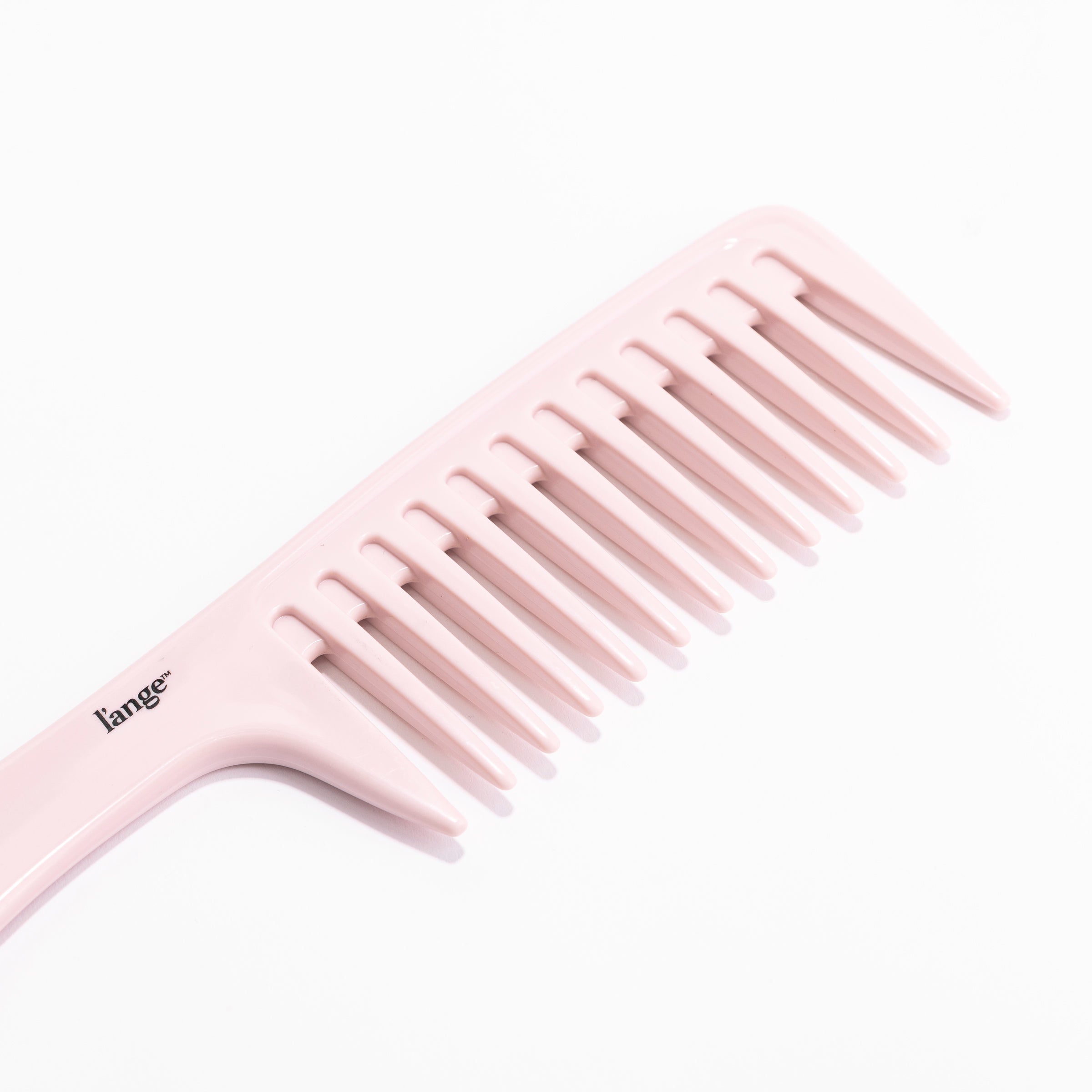 A close-up shows the thick, widely-spaced teeth of the pink detangling comb.