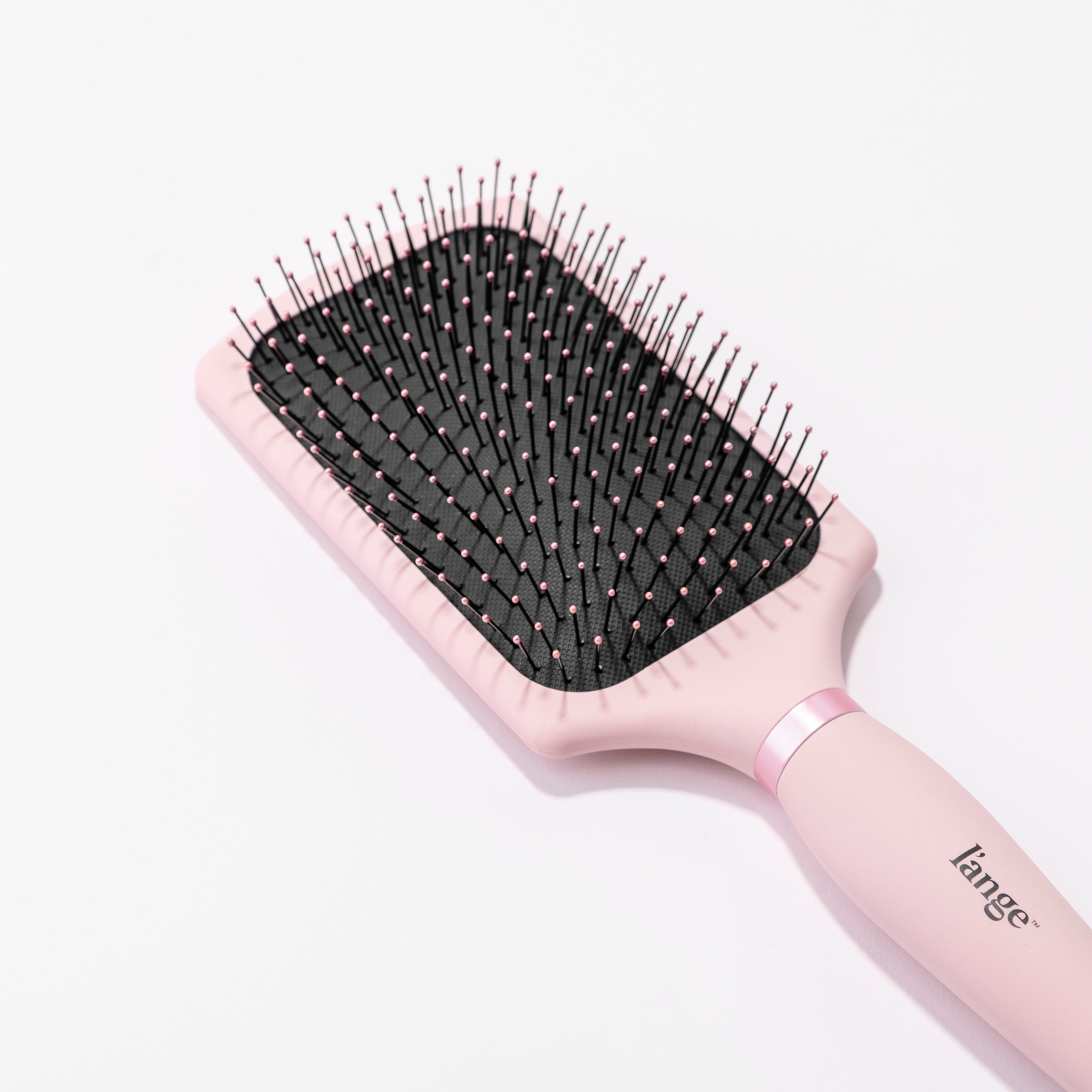 The rounded, pink-tipped nylon bristles are easy to see in this close-up of the paddle brush.