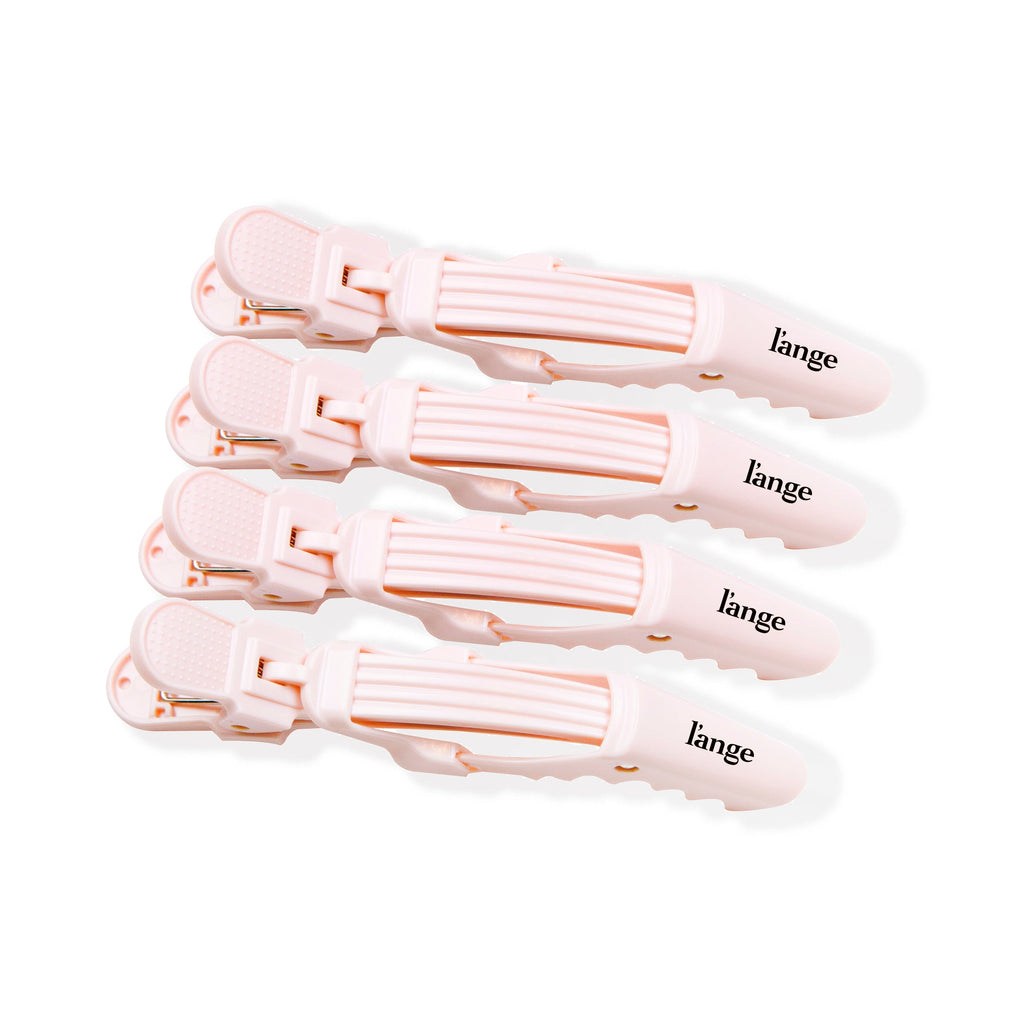 Four pink alligator hair clips are lined up side-by-side, displaying the logo and easy grips.