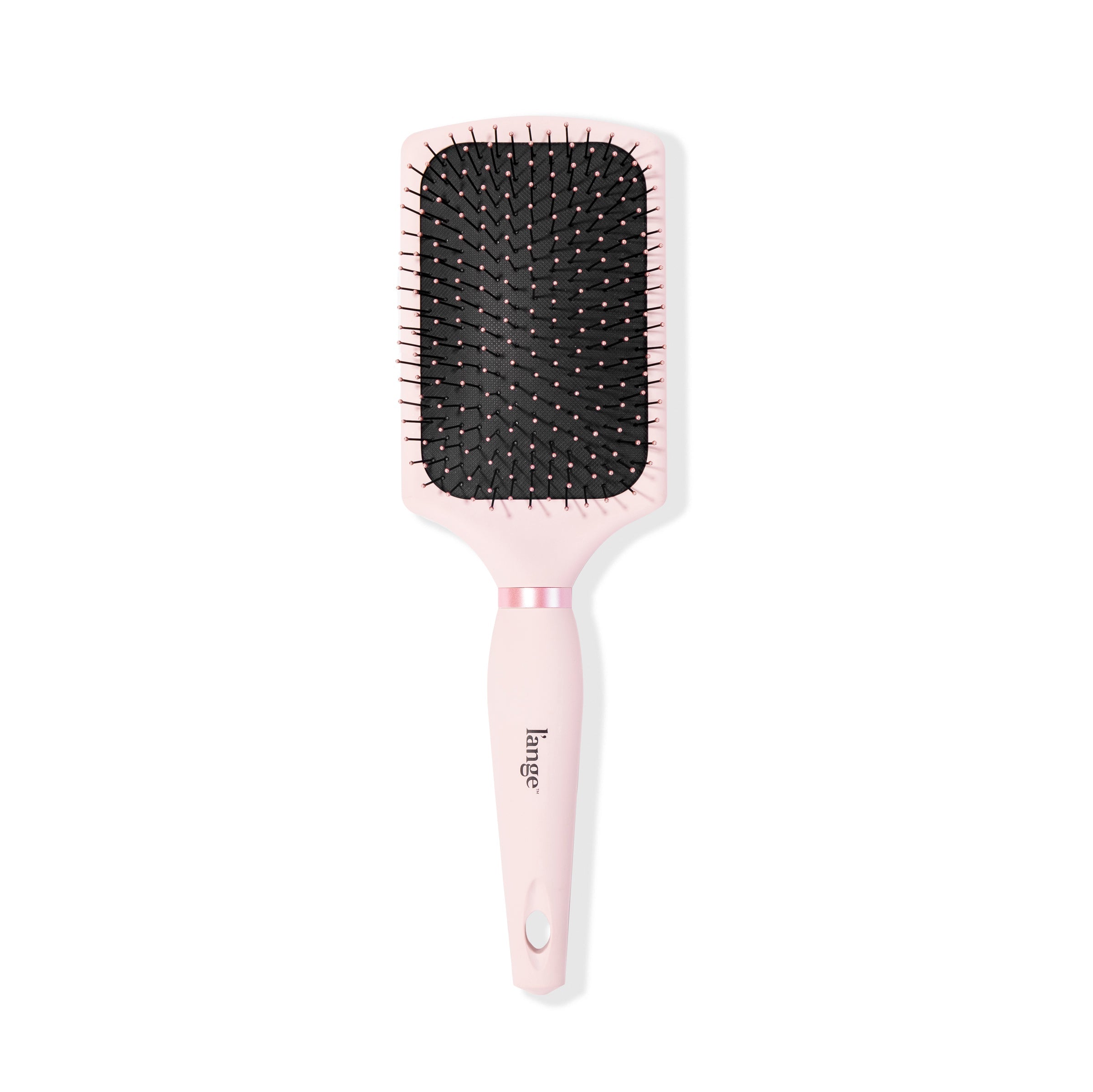 A blush-colored paddle brush stands vertically so you see the nylon bristles & soft-touch handle.