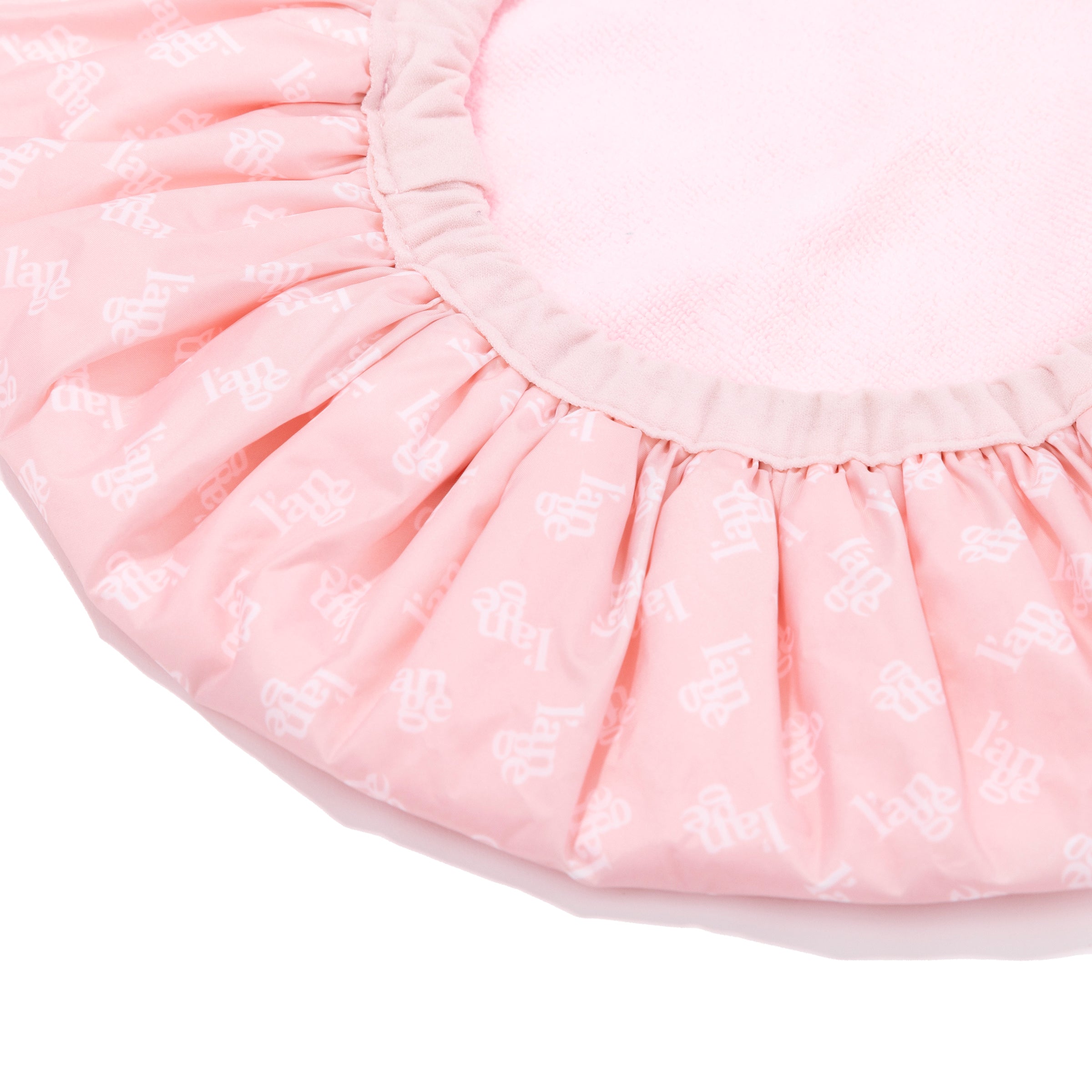A quarter of the reversible shower cap is visible so you see a close-up of the inside and outside.