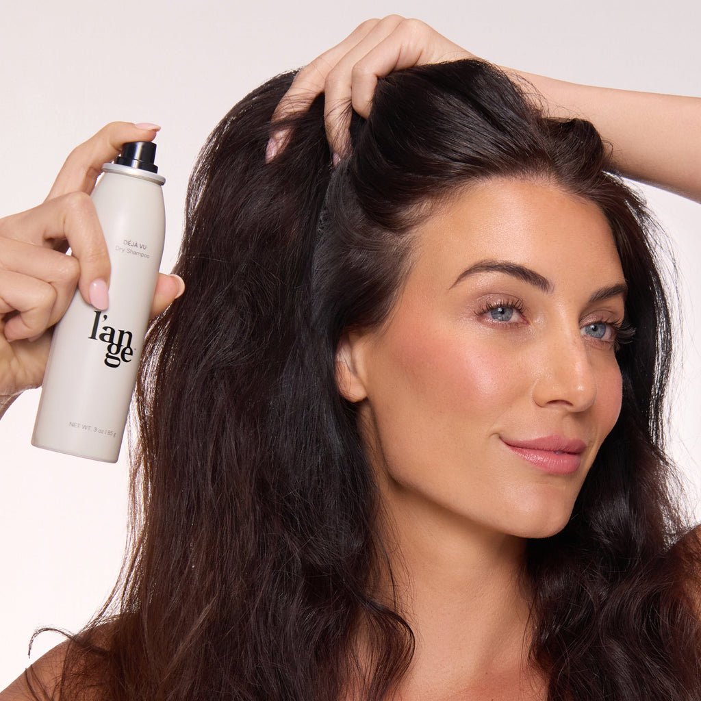 Model spraying Deja Vu Dry Shampoo onto hair.