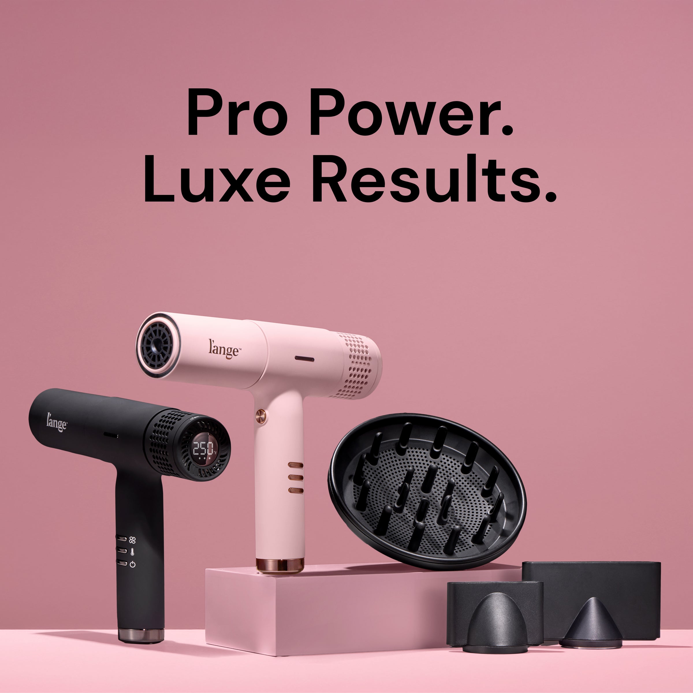 L’ange Le Styliste Luxe hair dryers in blush pink and matte black, shown with diffuser and concentrator attachments. Black text above reads: ‘Pro Power. Luxe Results.’ The black dryer displays ‘250°F’ on its rear digital screen.
