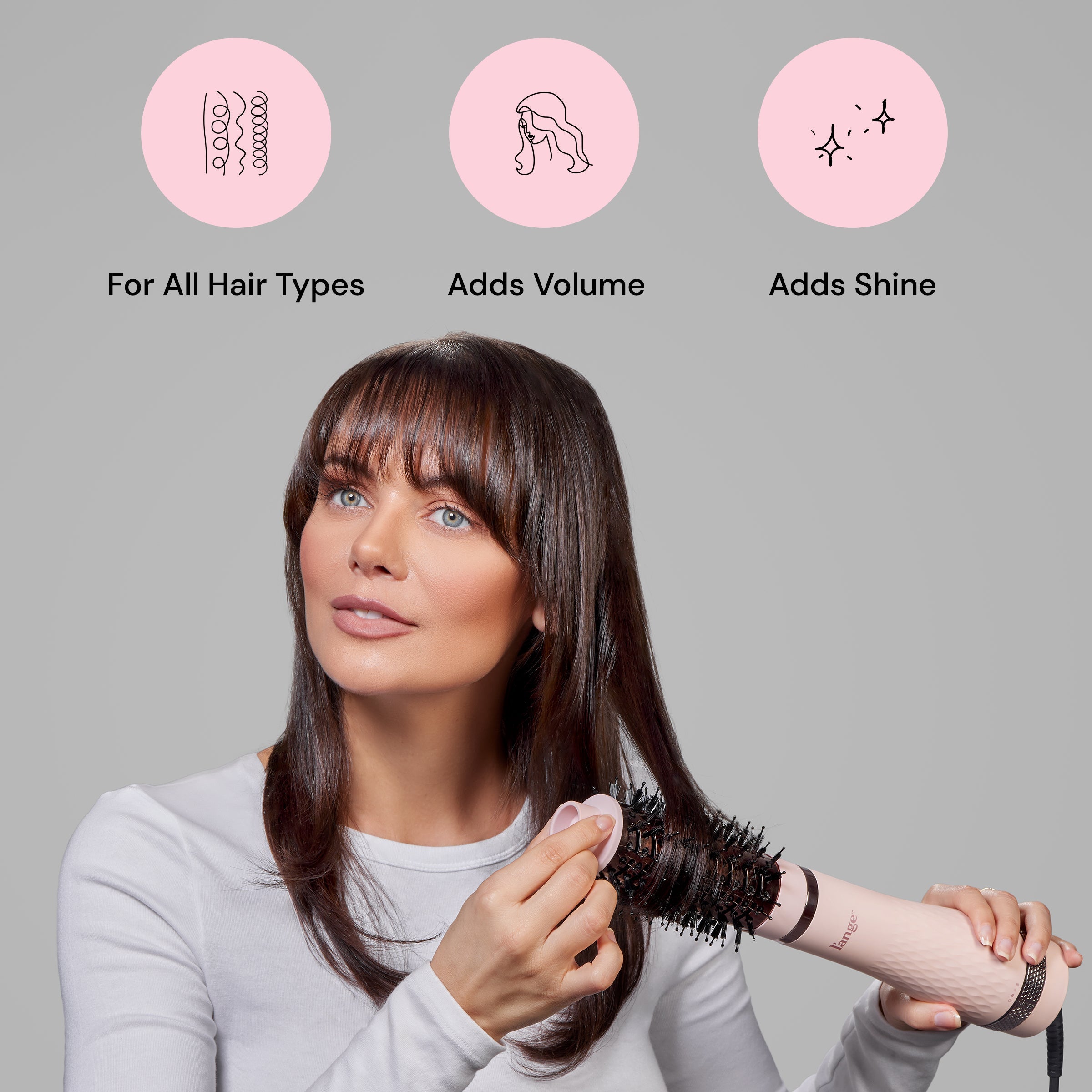 A dark-haired woman uses Multi-Volume Series below explanations of how it’s for all hair types, adds volume, & adds shine.