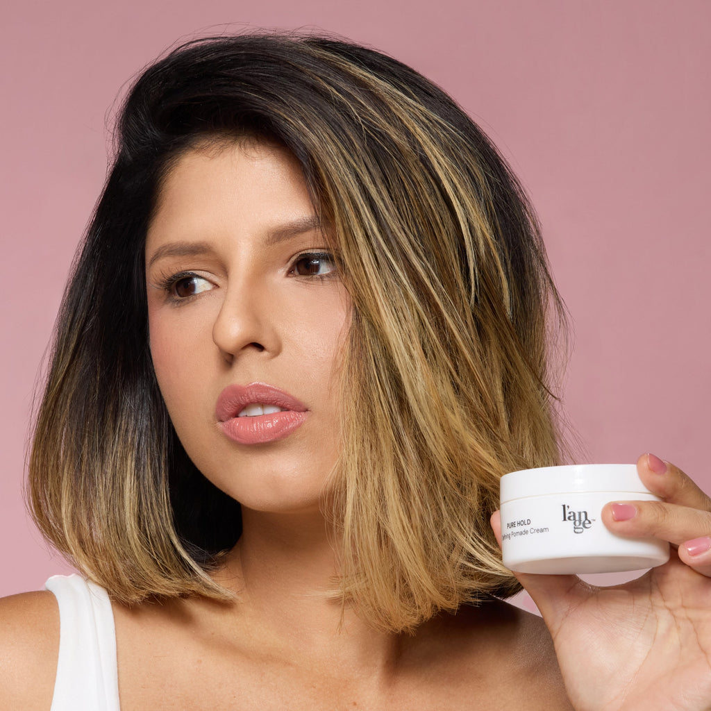 model holding a defining pomade cream jar with a neat styling look