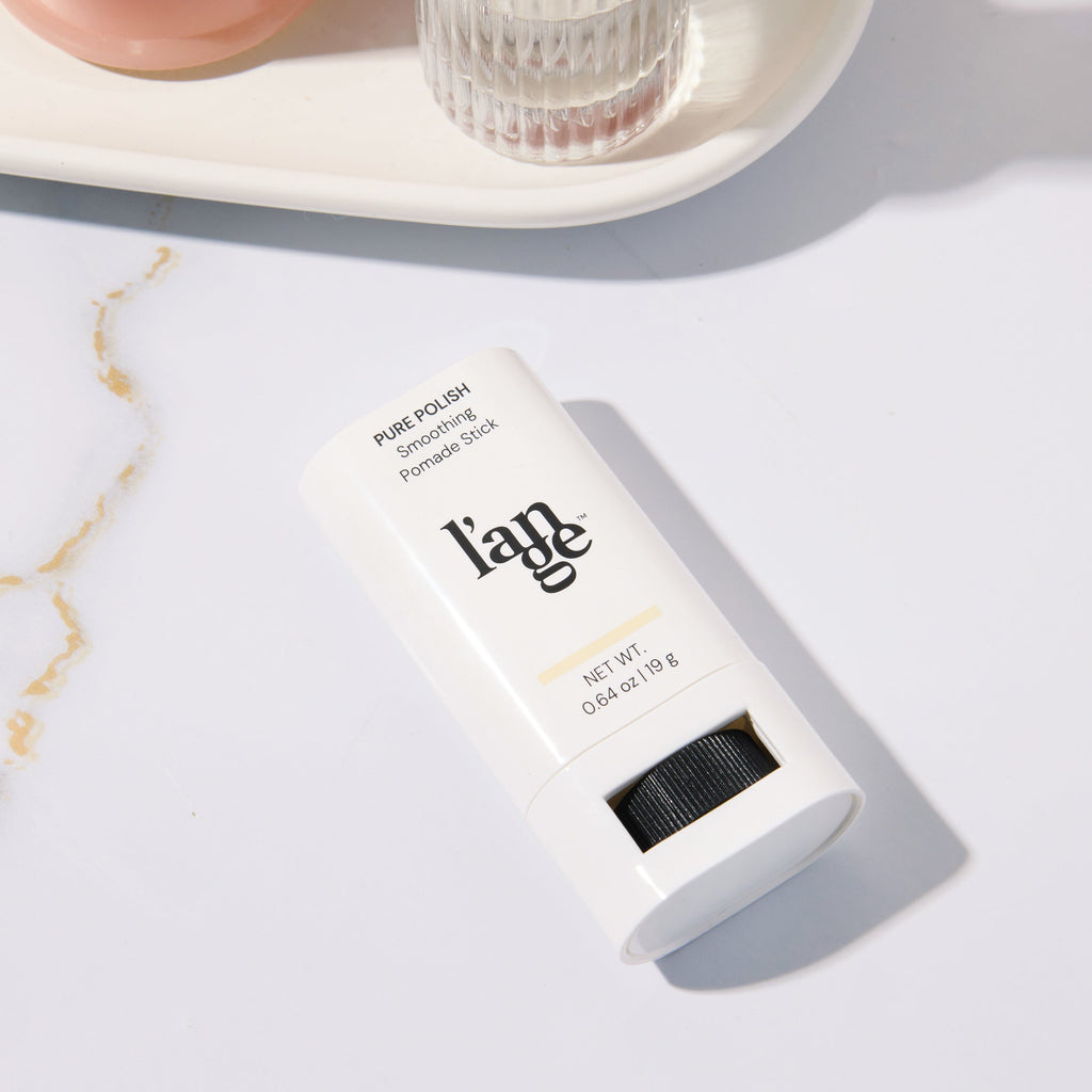 Smoothing Pomade Stick placed on a marble surface 