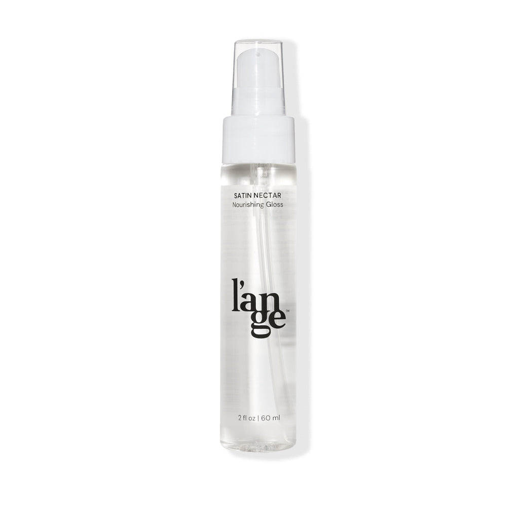 Clear spray bottle labeled "l'ange Satin Nectar Nourishing Gloss" containing 2 fl oz (60 ml) of product, with a white pump dispenser.