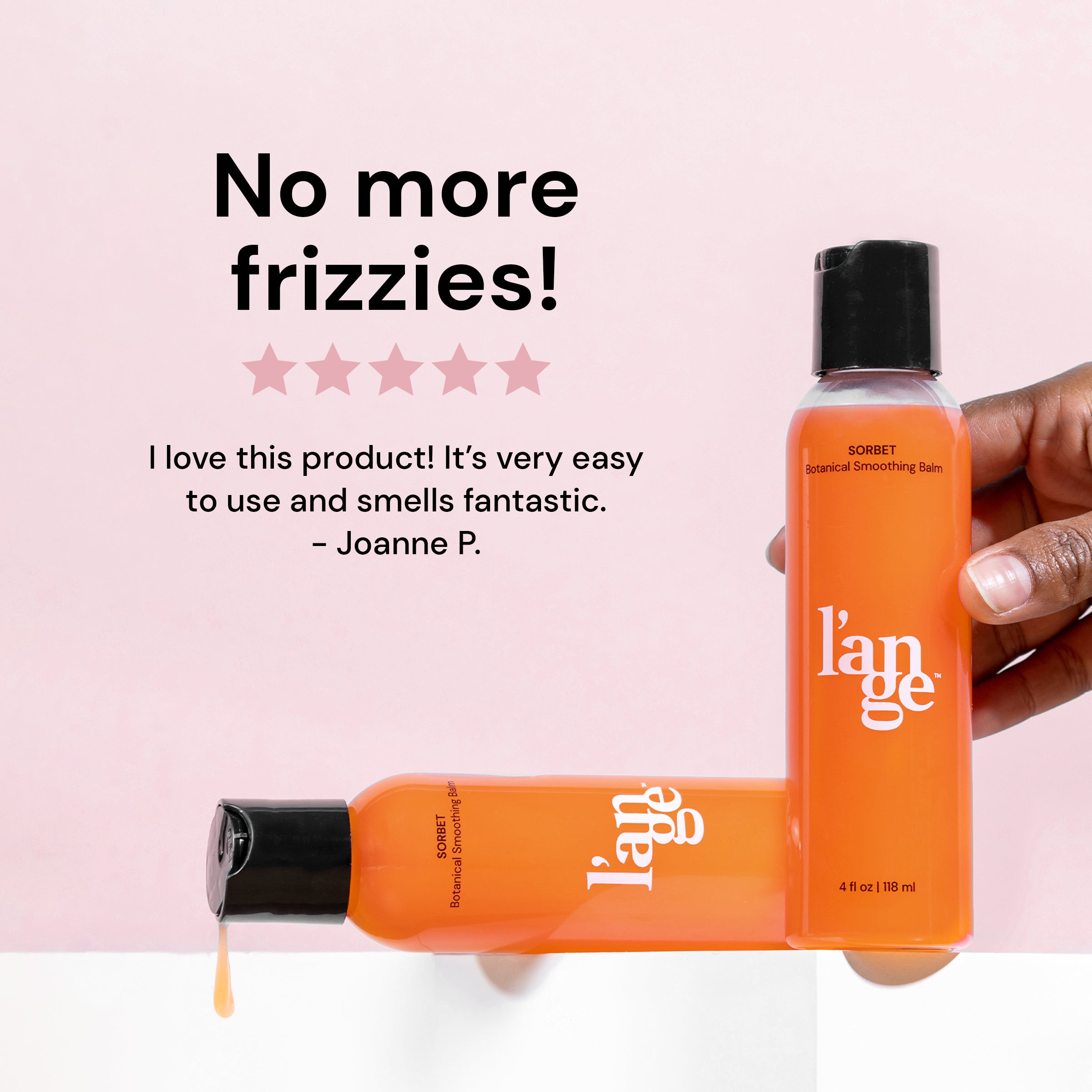 Two Sorbet Botanical Smoothing Balms placed in an L shape on a white prop. The standing bottle is being held by a model and the other bottle is laying flat on the prop while product leaks on the side. A customer review displays effortlessly above the bottles on a mauve background. 