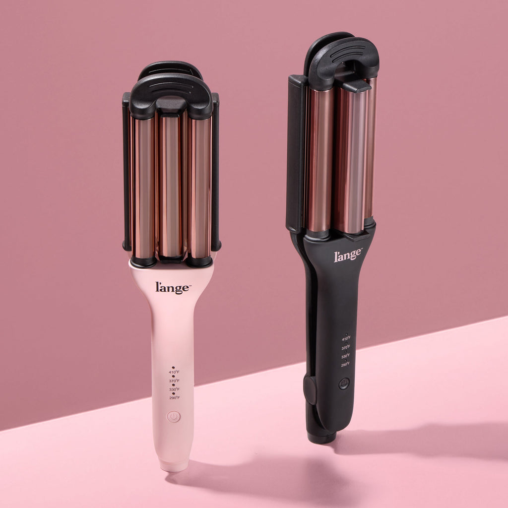 Two L’ange hair wavers, one blush and one black, standing upright against a blush background.